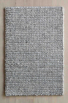 Textured gray rug on a wooden floor