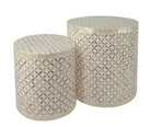 Two cylindrical mosaic tables with geometric patterns on a white background