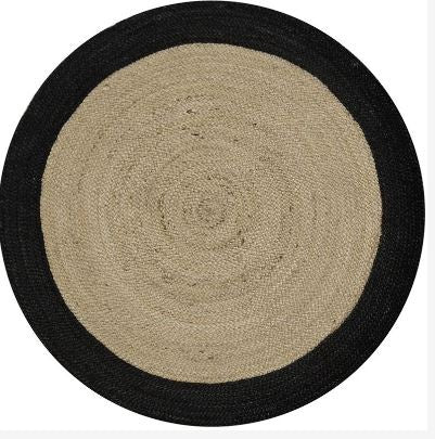 Round rug with black border and beige center on a white background