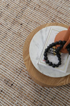 The Dune Ivory Jute & Wool Rug elegantly laid out in a lounge room, demonstrating how it complements and enhances a cozy and stylish living space.