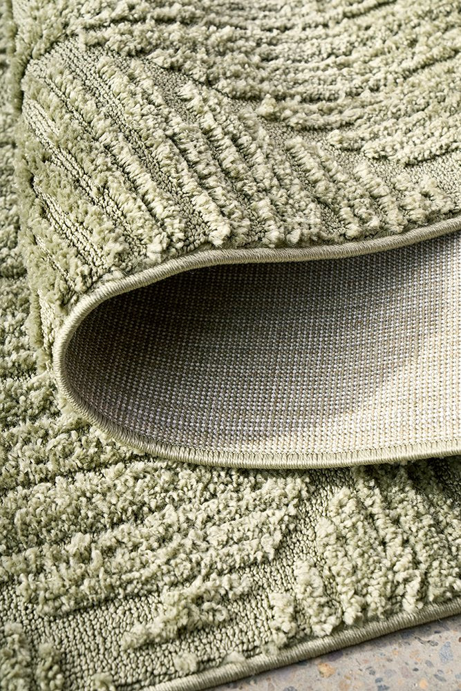 Close-up of a textured green rug with a slight sheen