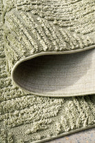 Close-up of a textured green rug with a slight sheen