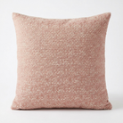 A square throw pillow in a textured, shimmering dusty rose pink fabric, photographed against a clean white background.