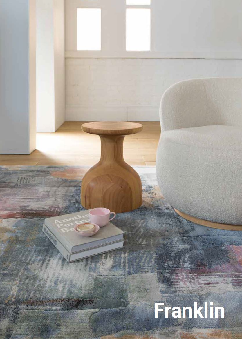 Living room with a textured rug, wooden side table, and gray armchair, featuring the brand 'Franklin'.