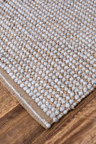 A close-up shot emphasising the handwoven quality of the rug, showcasing the skill and precision that goes into creating its stripped and textured loop design.