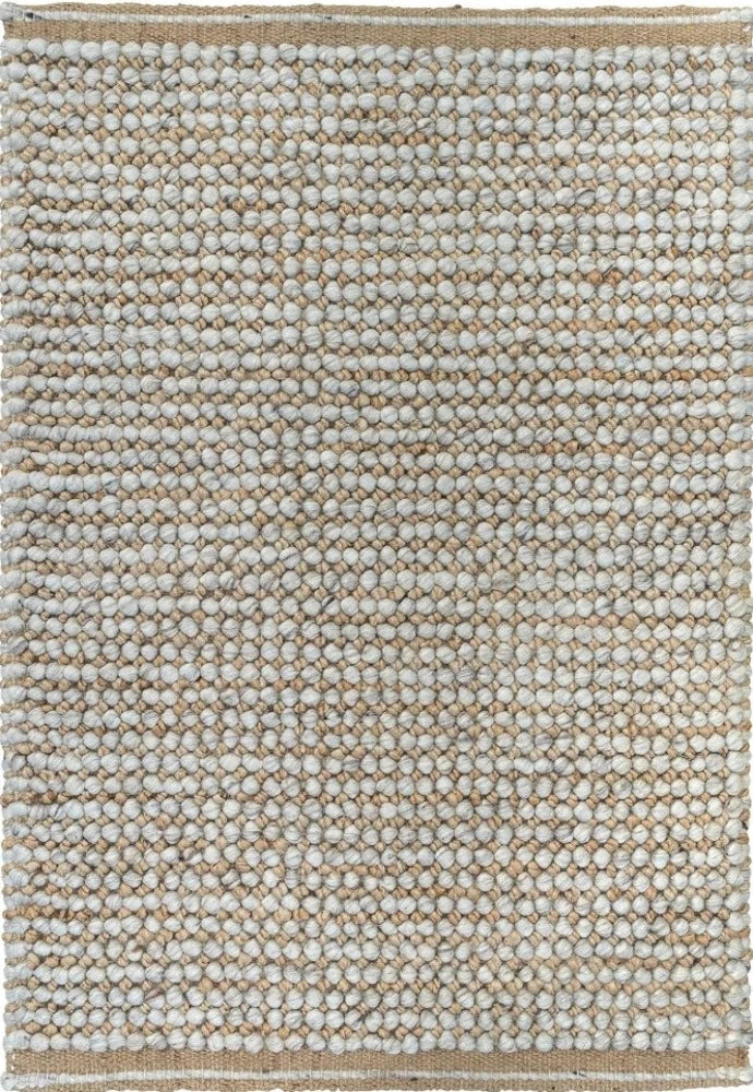 This image focuses on the fine details of the rug, highlighting the interplay between the natural and silver colors, and showcasing the unique texture created by the blend of wool and jute.