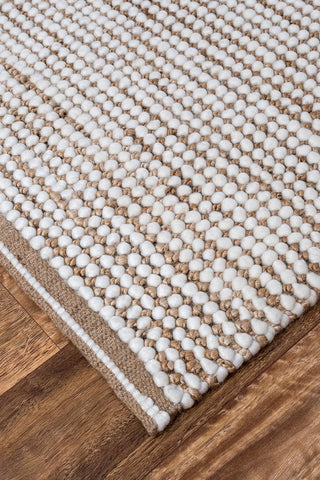 Showcasing the unique blend of wool and jute, this image highlights the rug's intricate texture and the interplay of natural and white colors, emphasising its rustic yet refined look.