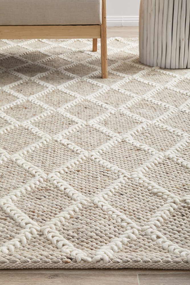 Textured area rug with geometric pattern on wooden floor