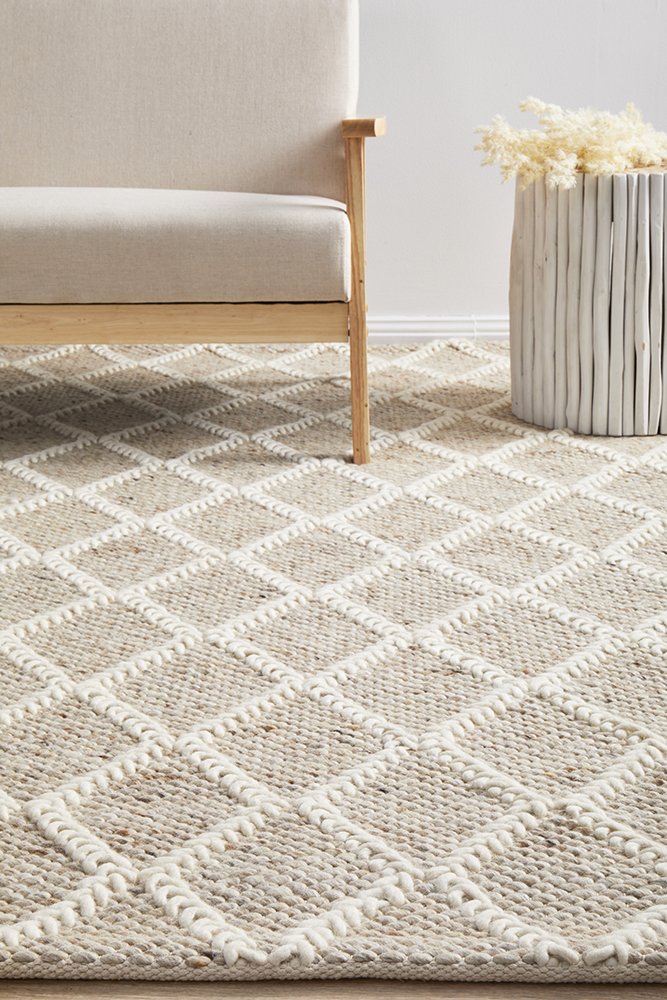 Patterned rug on a floor with a light-colored sofa and decorative item in the background.