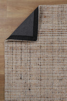 The Dune Jute & Wool Rug folded to display both its top and bottom surfaces, showing the uniform finish and artisanal quality.