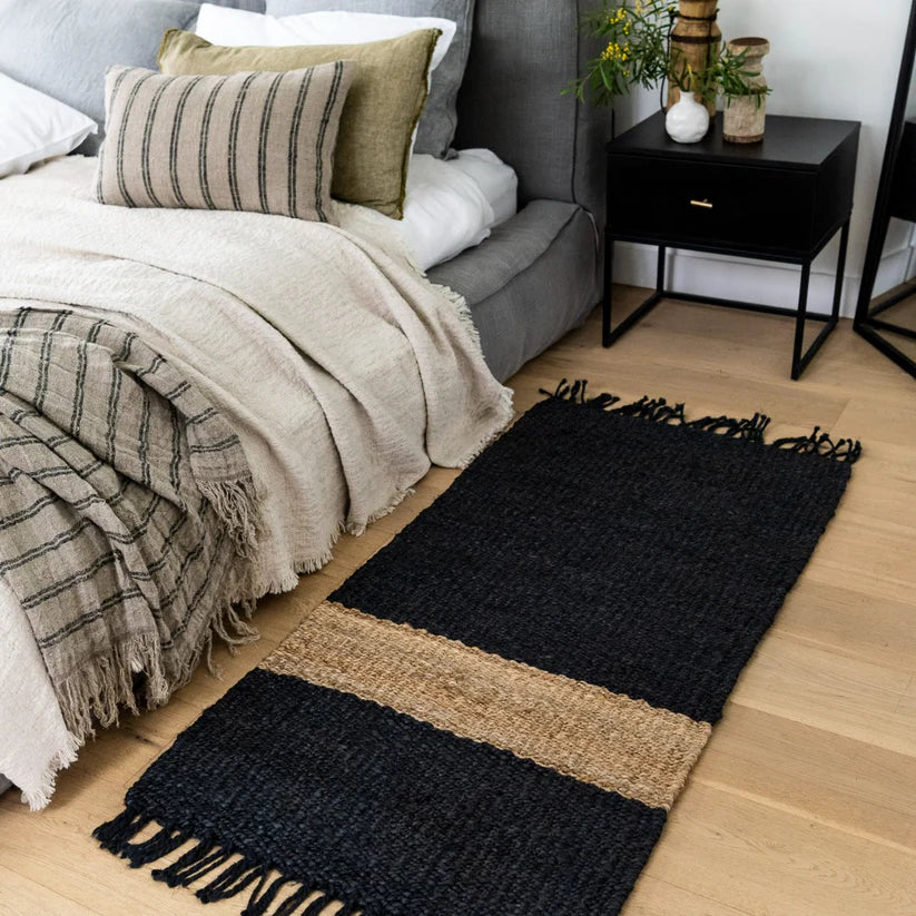 Bedroom with a black and beige rug on wooden flooring