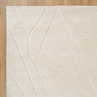 Beige rug with geometric pattern on a wooden floor