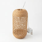 A natural woven rattan or wicker cylindrical lantern with an openwork pattern, shown on a clean white background with a hanging tag.