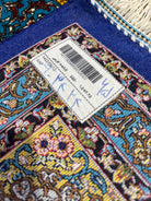 Close-up of a colorful rug with a label on a blue background