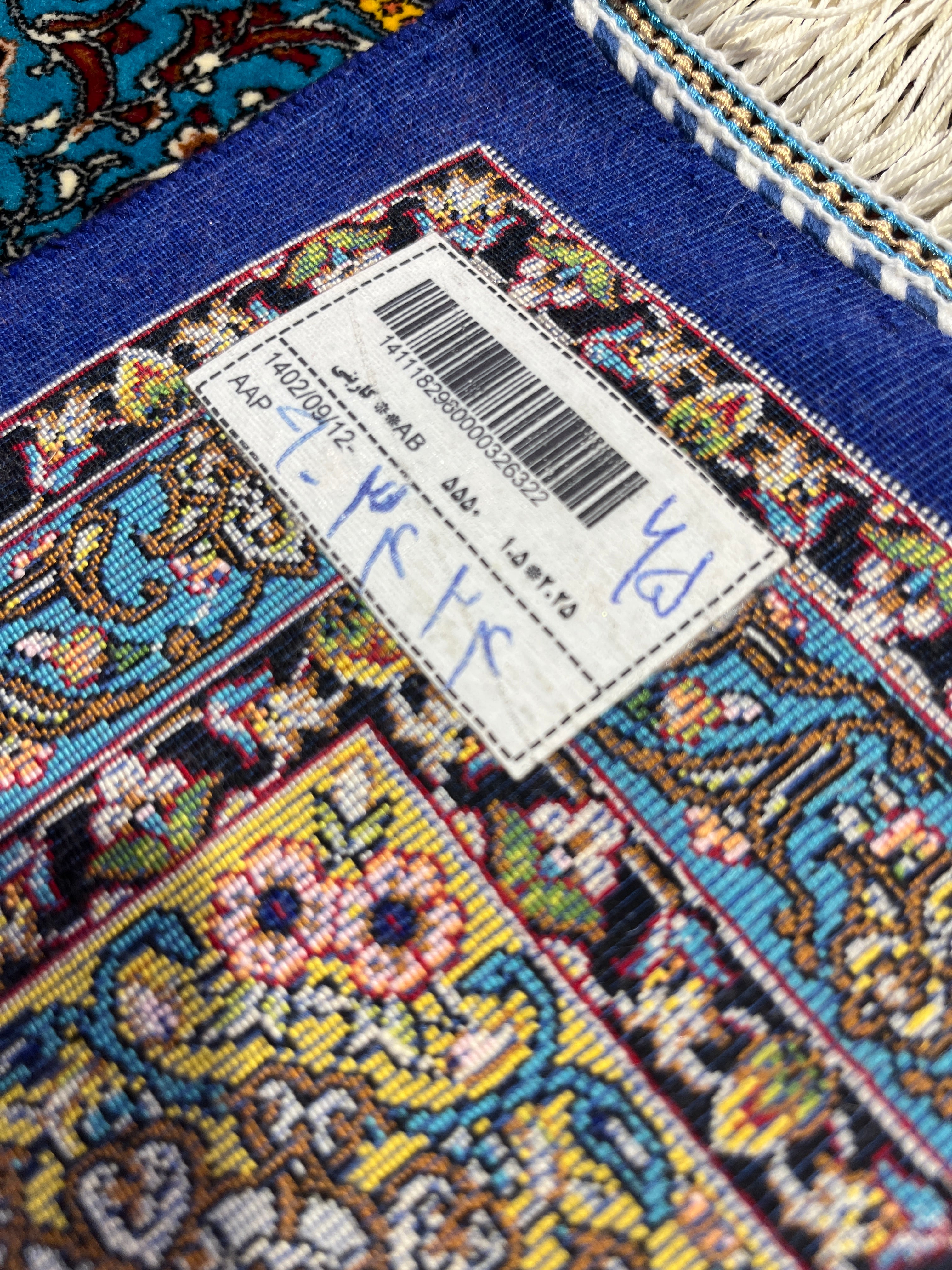 Close-up of a colorful rug with a label on a blue background