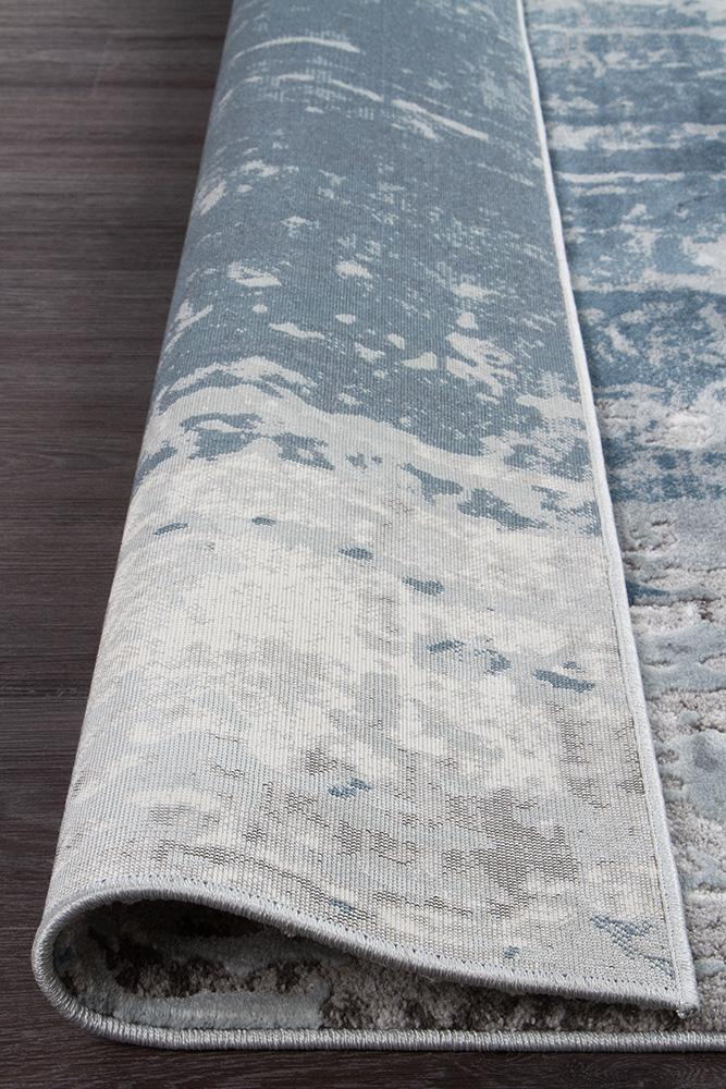 The Kendra Rug in Blue rolled up, showcasing its flexibility and ease of handling, ideal for storage and transport.