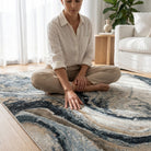 Woman sitting on a patterned rug in a living room