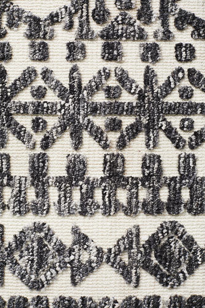 Detailed close-up highlighting the intricate geometric and nomadic figures on the Levi Rug in Ivory Black, emphasising its artistic and modern design.