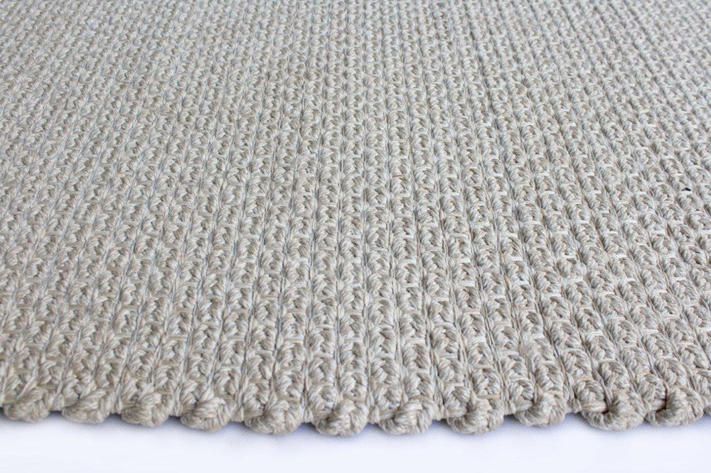 Close-up of a textured beige carpet on a white background