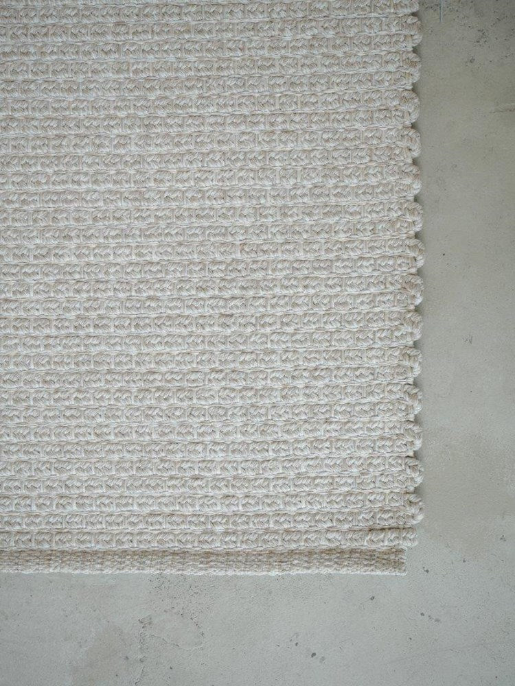 Textured white rug on a light gray floor