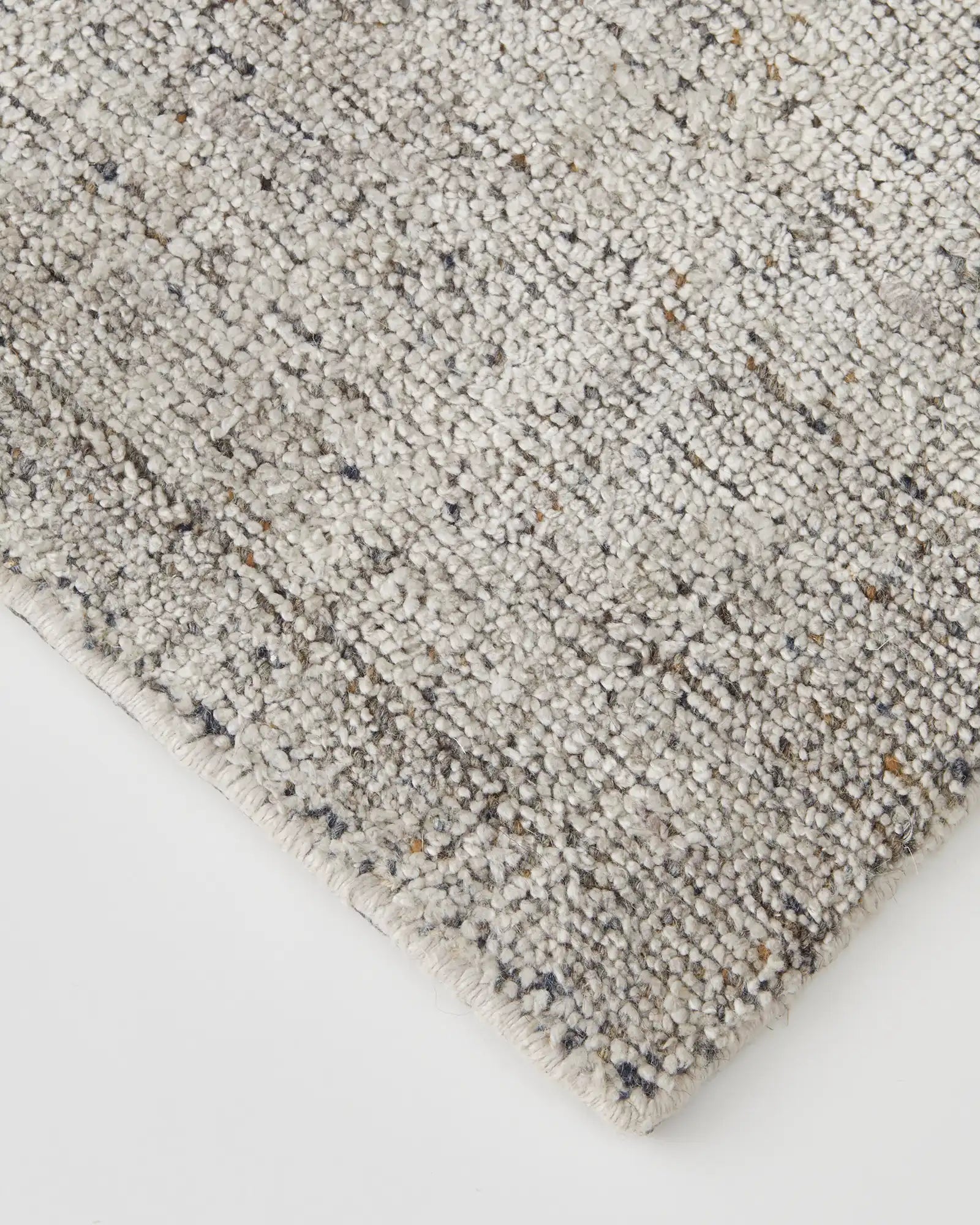 Detail of the rug's edge showing the precise loom-knotted craftsmanship and quality finish."
