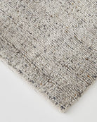 Detail of the rug's edge showing the precise loom-knotted craftsmanship and quality finish."
