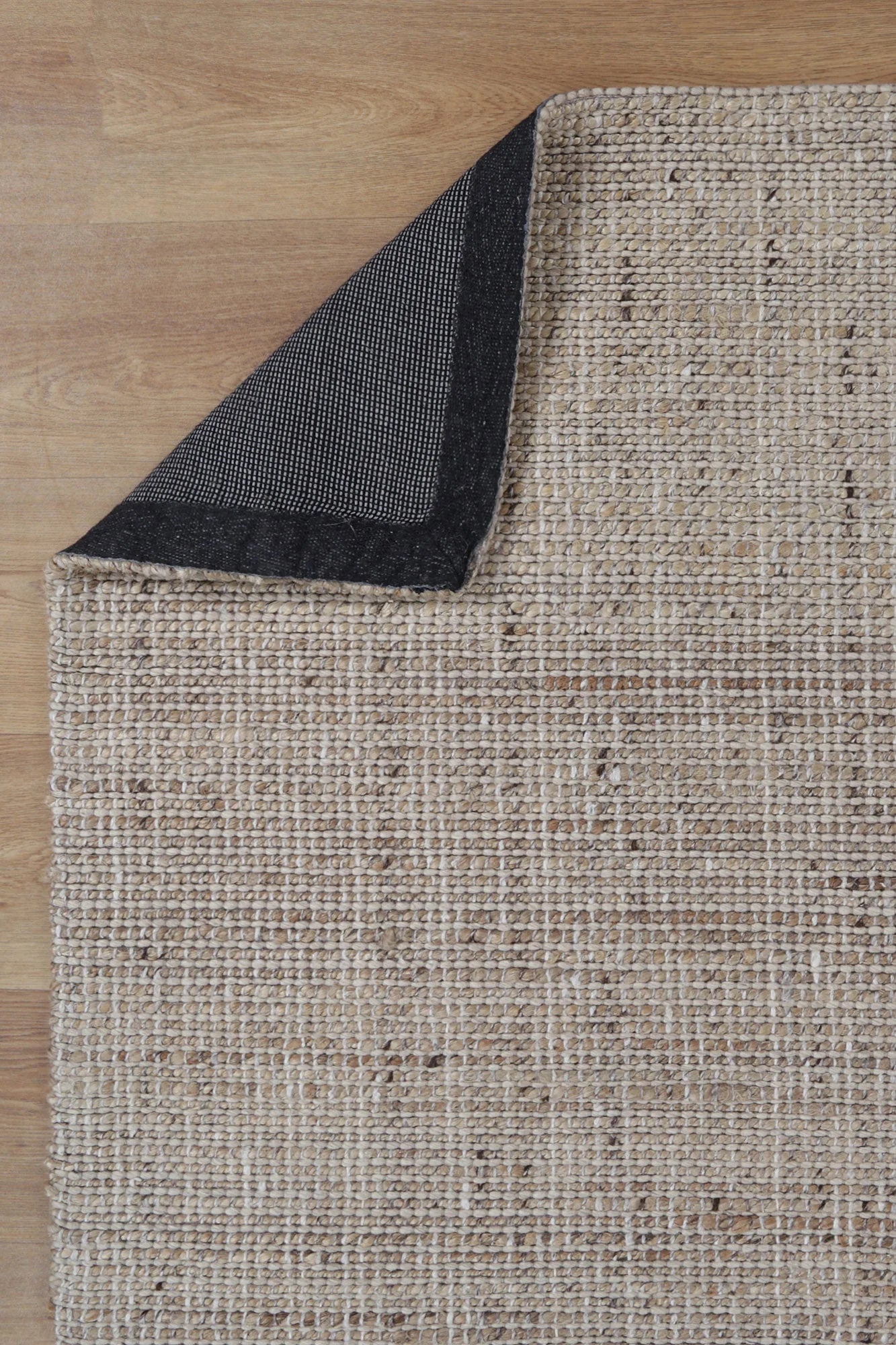 Image of the Dune Jute & Wool Rug folded to display both the top and bottom sides, showcasing the consistent quality and finish across its entire design.