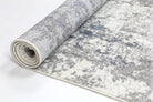 Rolled Bohemian Paradise rug showcasing its grey-blue hues and intricate pattern details.