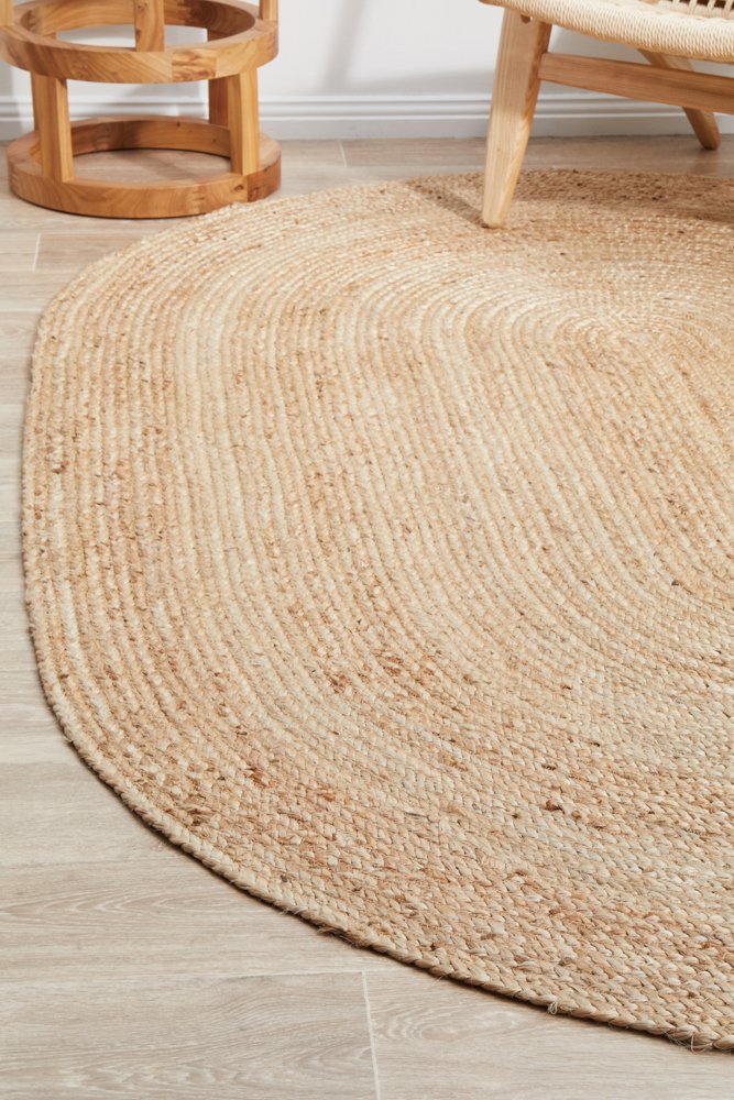 Round jute rug on a wooden floor with wooden furniture.