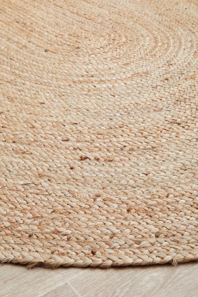 Close-up of a textured beige woven rug on a light wooden floor.