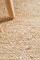 Close-up of a woven jute rug with a wooden chair leg.