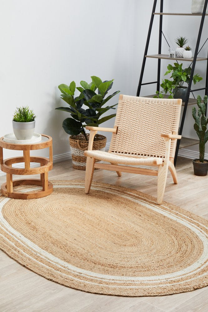 Woven chair on a jute rug with plants and a ladder in the background