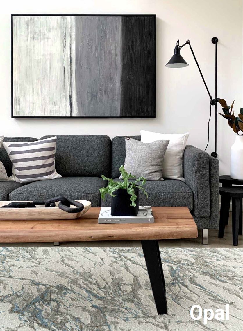 Modern living room with gray sofa, wooden coffee table, and abstract painting.