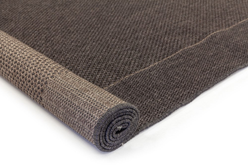 Rolled-up brown textured rug on a white background