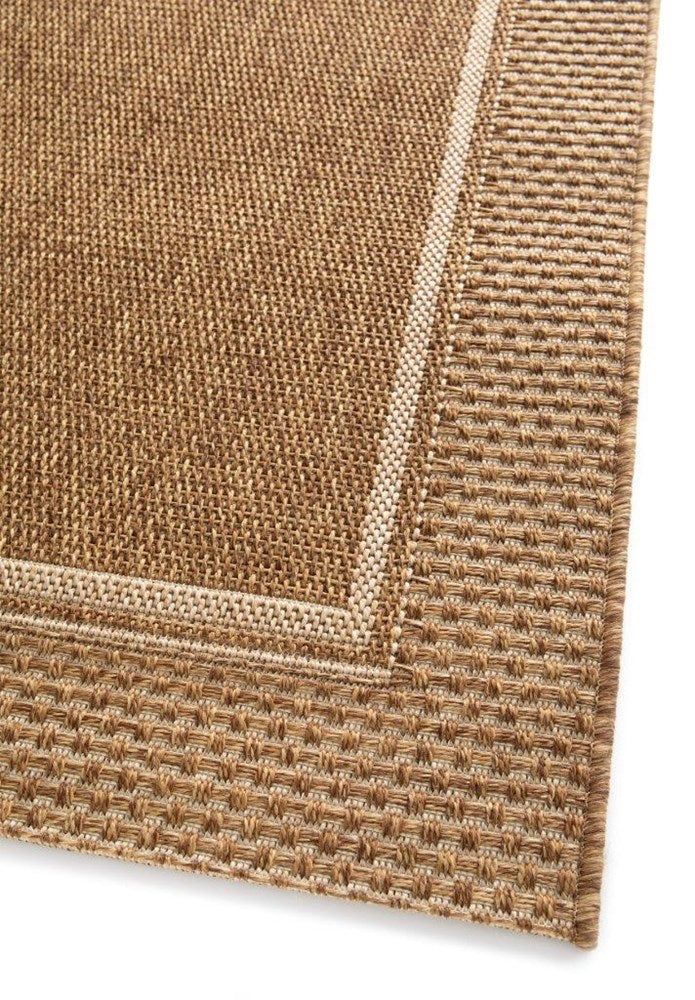 Close-up of a textured brown rug corner on a white background