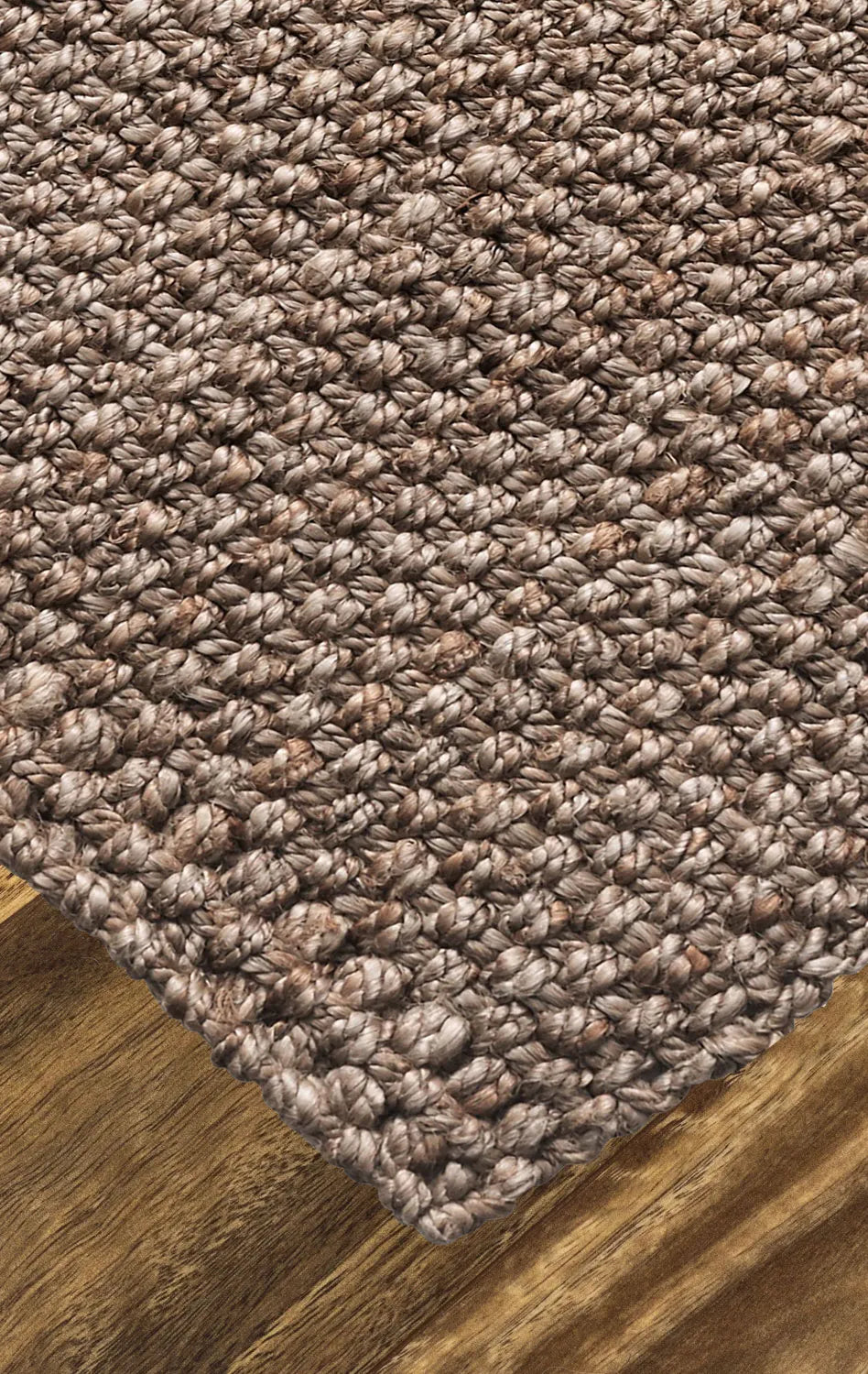 Close-up of a textured brown carpet corner on a wooden floor