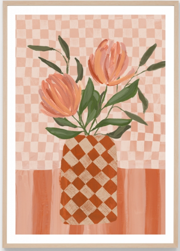 A framed art print featuring a stylized illustration of two peach-orange tulips with green leaves in a checkered terracotta and cream vase, set against a pink and peach checkered background.