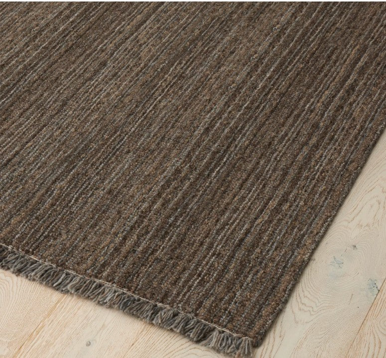 Brown textured rug on a light wood floor