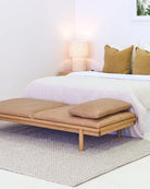 Bedroom with a bed and wooden bench featuring cushions.