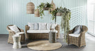 Outdoor furniture set with wicker chairs, sofa, and side table on a wooden deck.