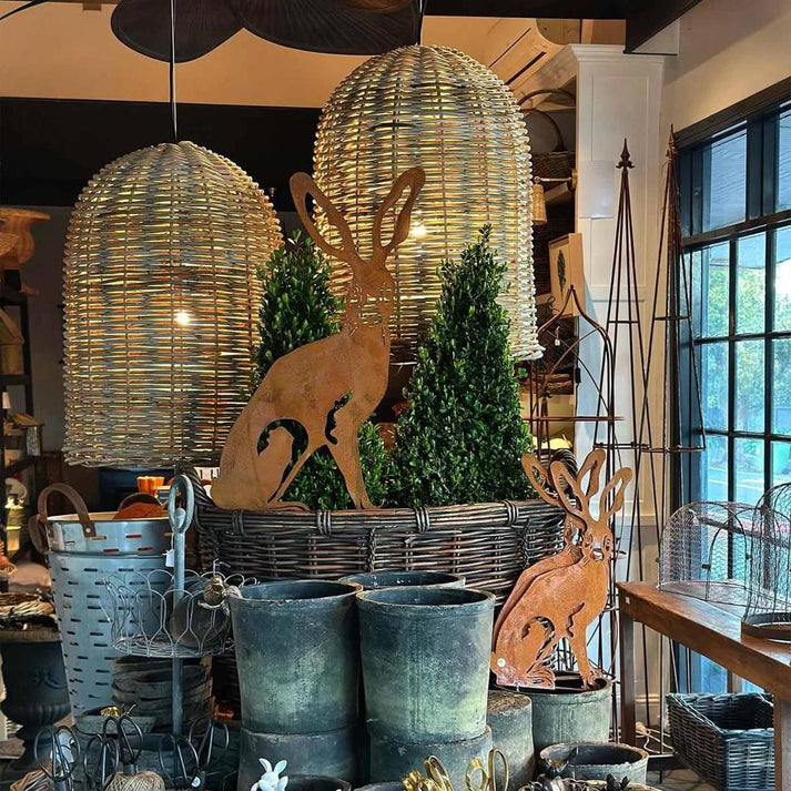 Decorative hares and wicker baskets in a store setting with large hanging lights.
