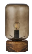 A table lamp with a smoky translucent glass shade and a round dark wood base, shown against a plain white background.