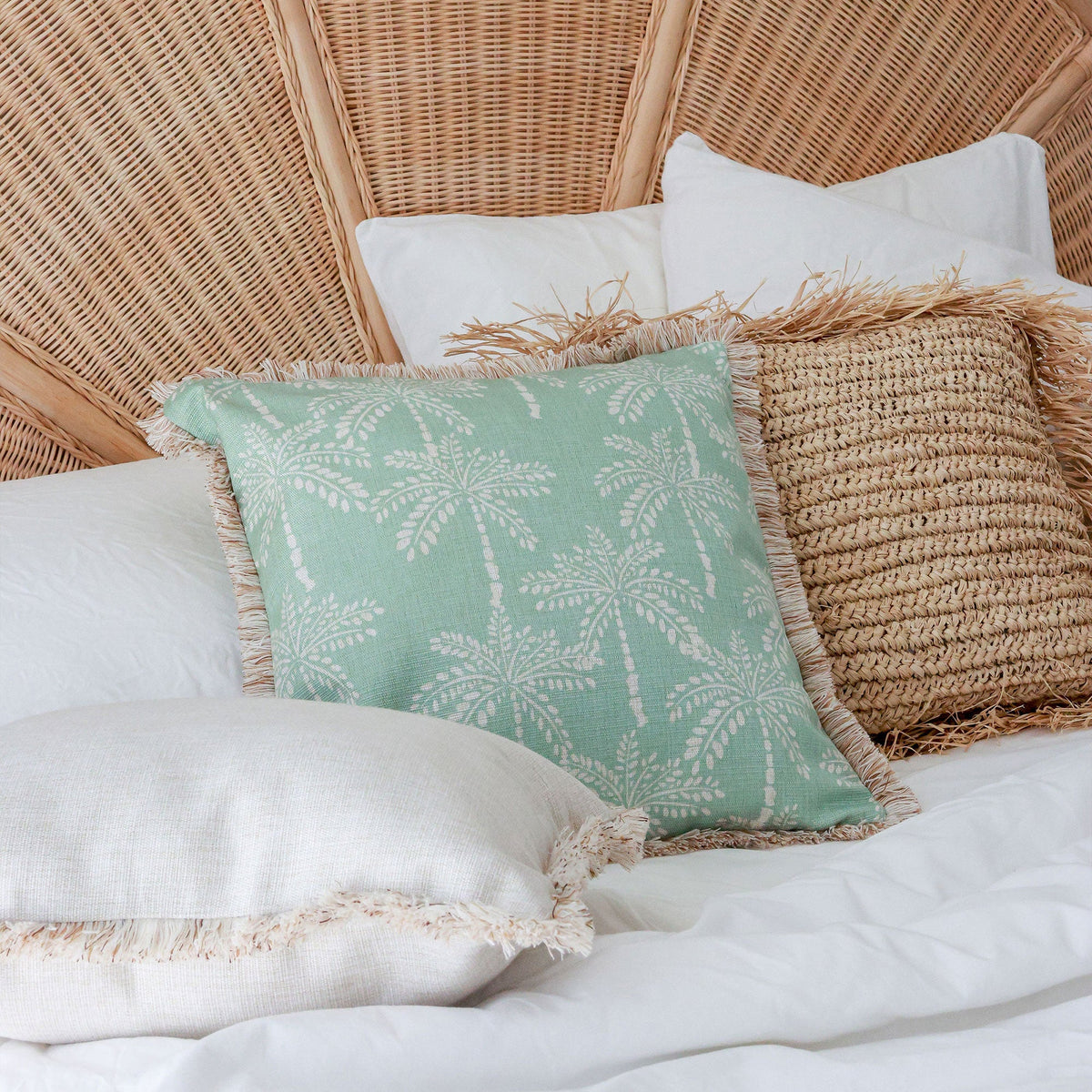 Decorative pillows on a bed with a wicker headboard