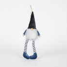 A plush gnome decoration with a tall black pointed hat, white faux-fur face and beard, blue sleeves, gray-and-white striped legs, and blue shoes, shown against a plain white background.
