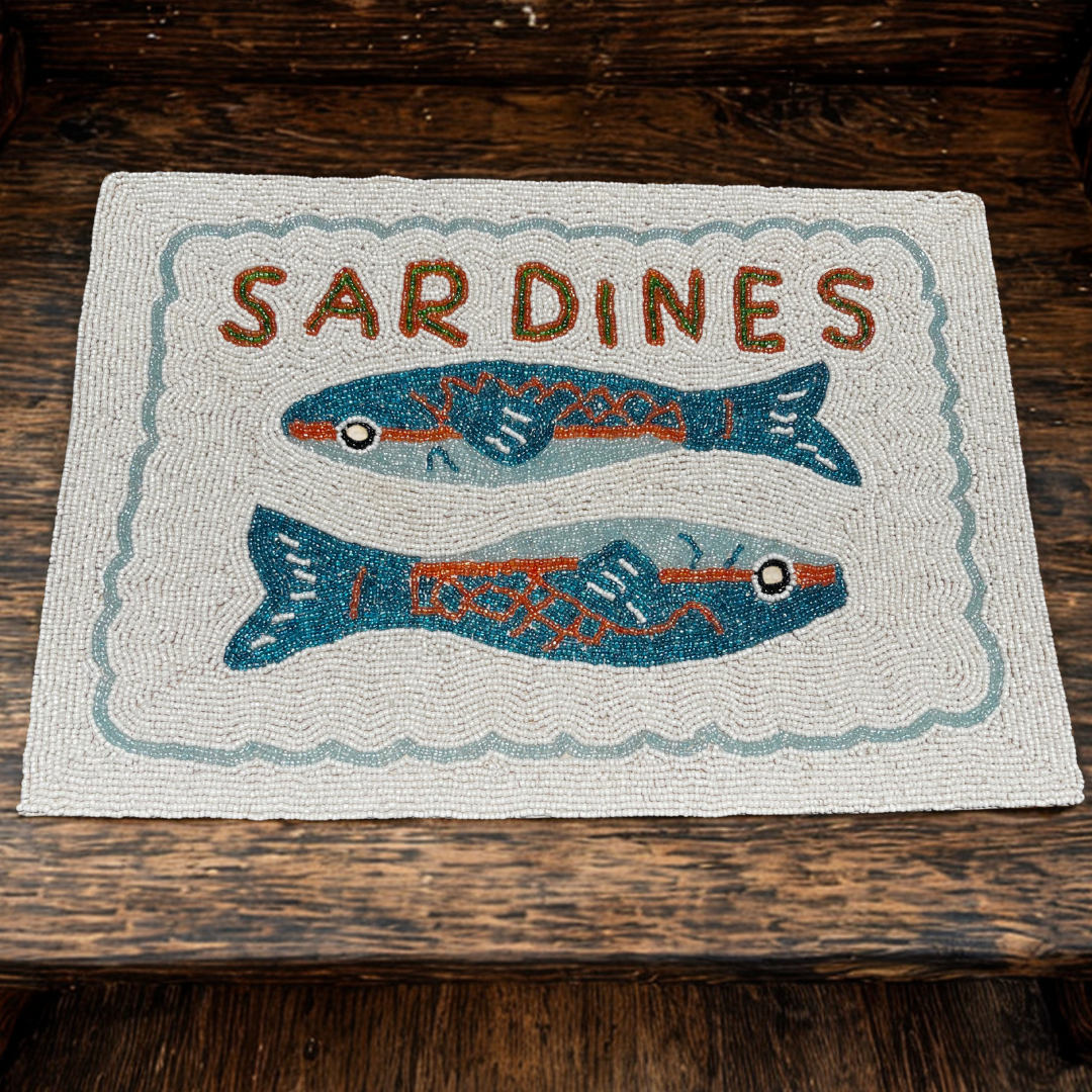 Textile with 'Sardines' and fish illustrations on a wooden surface