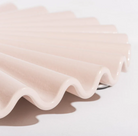 Pink ceramic vase with wavy design on a white background