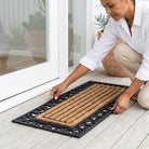 Person installing a doormat on a wooden floor Noosa Rugs