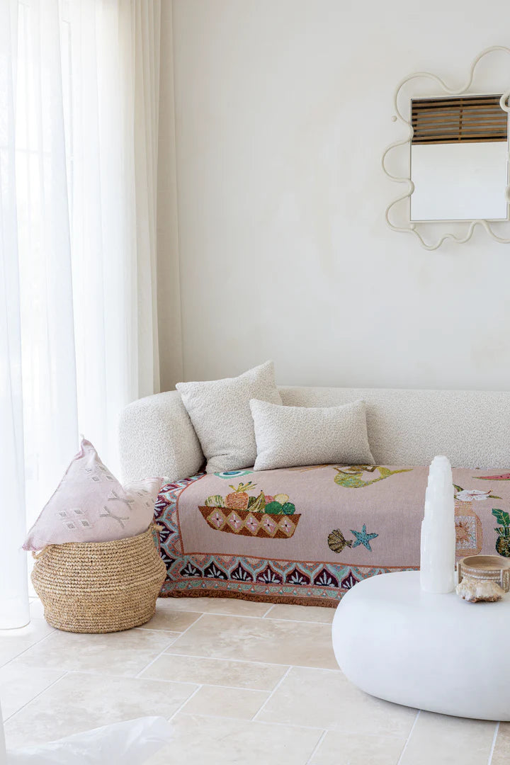 Living room with a white sofa, decorative pillows, and a colorful blanket.