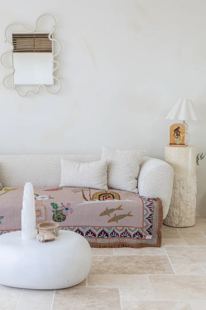 Living room with a white sofa, decorative pillows, and a patterned throw rug.