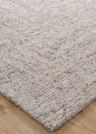 Close-up of a textured beige rug on a wooden floor